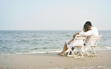 Couple relaxing on beach near our static caravans for sale in Prestatyn