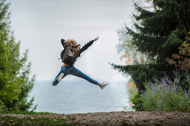 a girl jumping in a woods in North Wales