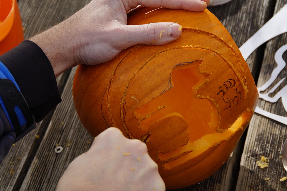 A person carving a pumpkin